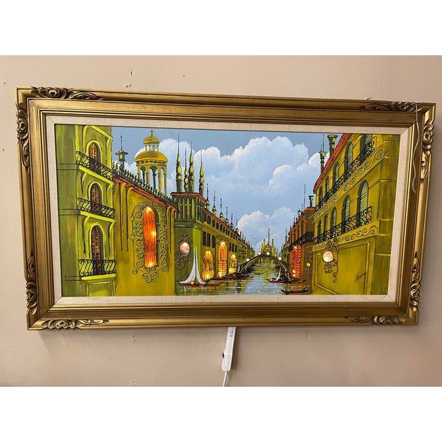 This decorative light up oil painting depicts an idealized Venetian canal lined with ornate palazzi, gondolas, and softly...