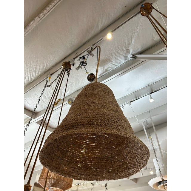 Large natural woven basket pendant featuring a sculptural bell-shaped silhouette and tightly coiled woven construction....