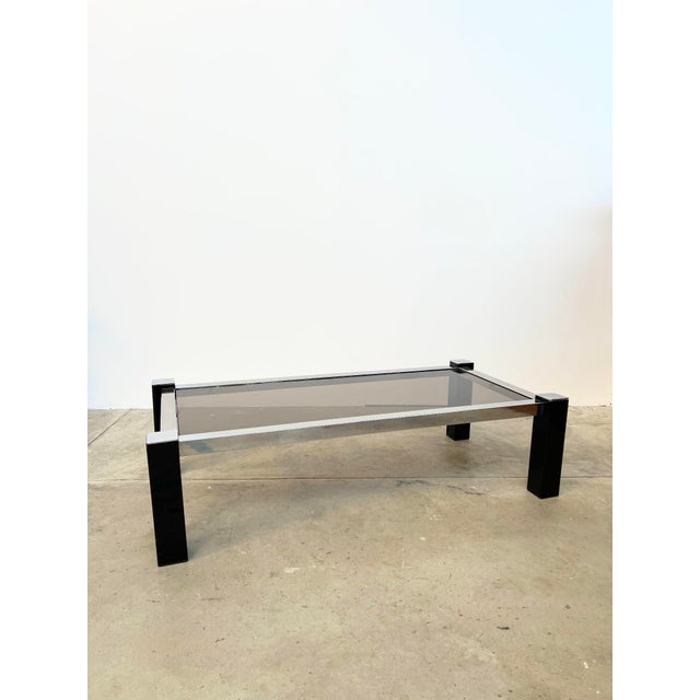 This 1970s coffee table embodies the graphic elegance and minimalism of the "Lounge" era. Its structure rests on a tubular...
