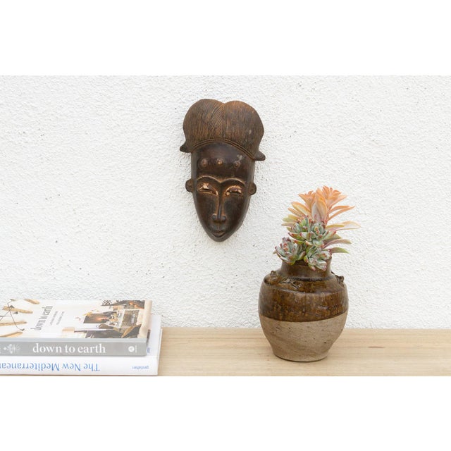 Discover the captivating allure of authentic African art with this vintage hand-carved wooden mask. Imbued with a rich...