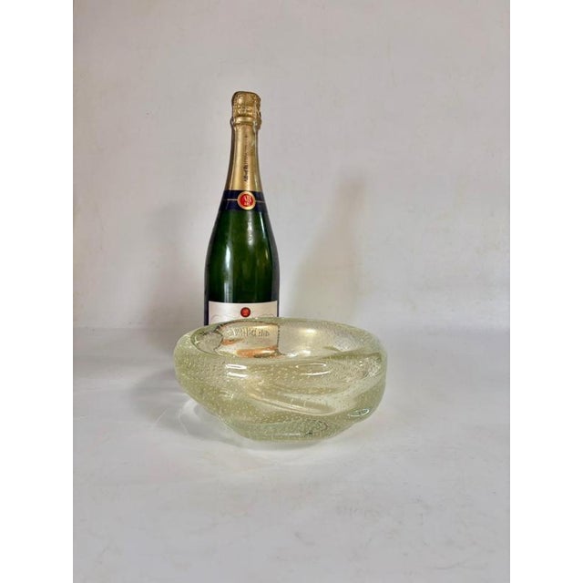 It's a Bulé yellow glass ashtray with decorations inside. The color is somewhere between transparent and yellow-green. The...