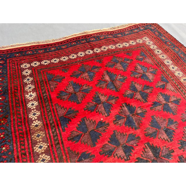This vintage Afghan Baluchi hand-knotted rug displays a beautiful tribal star lattice design woven in rich tones of deep...