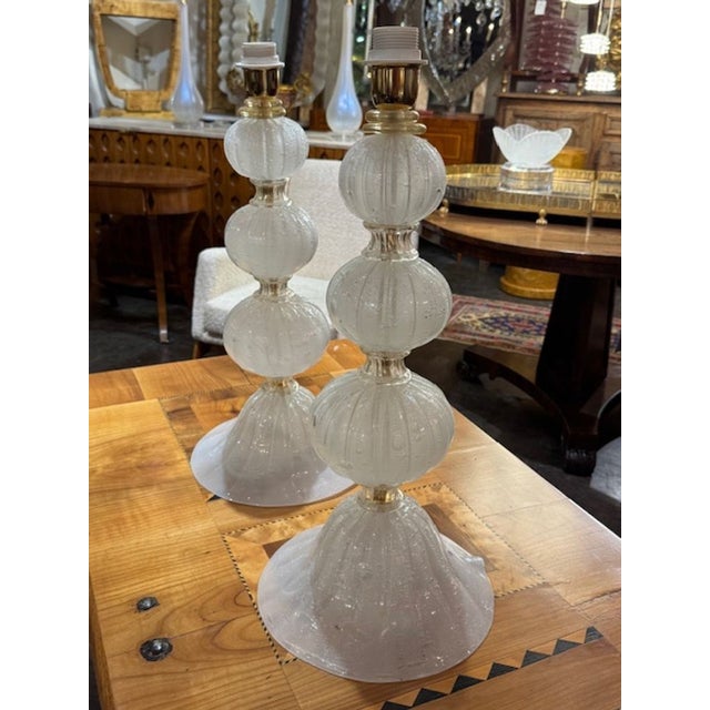 The product is a pair of modern silk Murano glass lamps. These lamps feature a sleek and contemporary design, adding a...