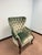 Classic tufted upholstered accent chair featuring rich green velvet fabric, rolled arms, and gracefully curved wooden...