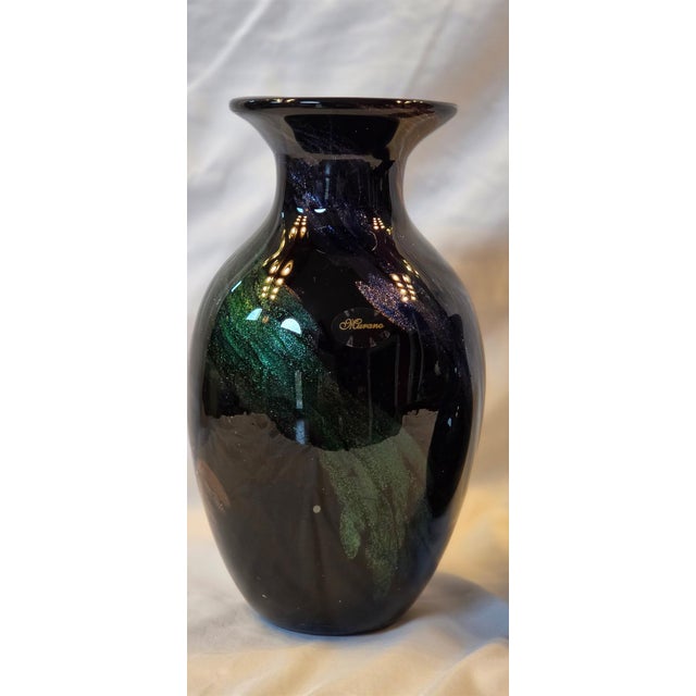 A striking pair of vintage Murano hand-blown art glass vases. Each vase features a deep, glossy black grown infused with...