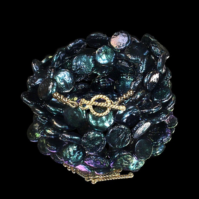 This 28‑inch iridescent blue‑green coin pearl necklace becomes a standout piece the moment it’s worn, thanks to its...