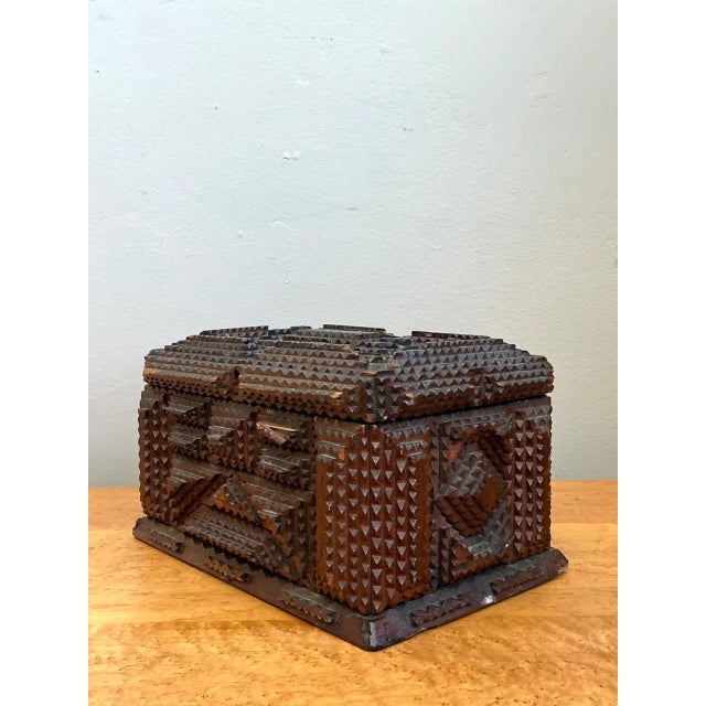Crafted using intricate chip-carving and layered whittling techniques, this vintage folk art tramp art box features a...