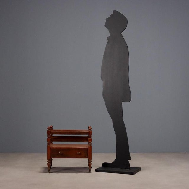 Mahogany magazine rack. Open magazine rack with a central drawer underneath. Turned legs with cup holders and casters....