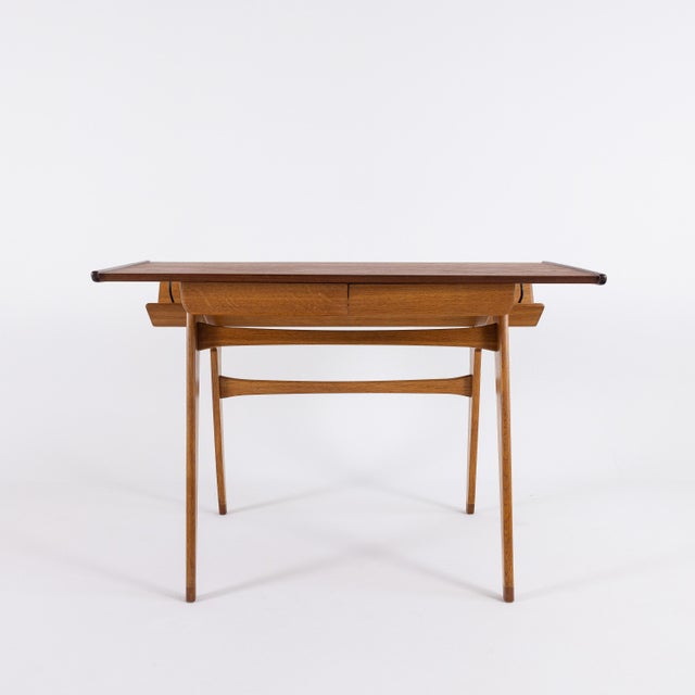 An outstanding example of French post-war furniture design: This rare teak and oak desk is attributed to the leading...