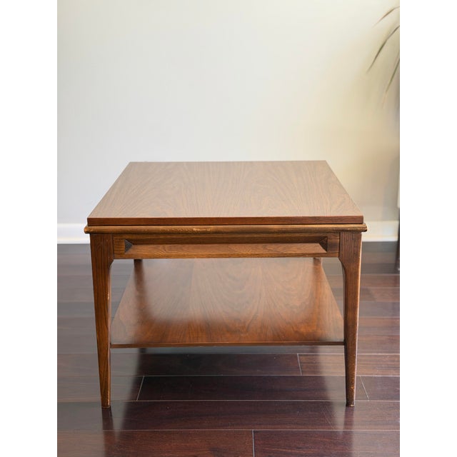 A sculptural 1960s mid-century modern end table with a richly grained walnut top, architectural floating-top construction,...