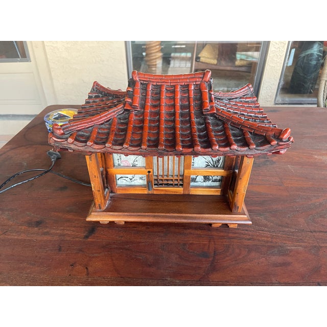 Experience the charm of traditional Korean architecture with tile-roofed house-shaped lamp. Featuring a detailed toenmaru...