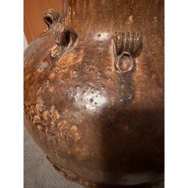 This Chinese Qing dynasty period Martaban jar from the 18th-19th century has dragon motifs and loop handles. It comes from...