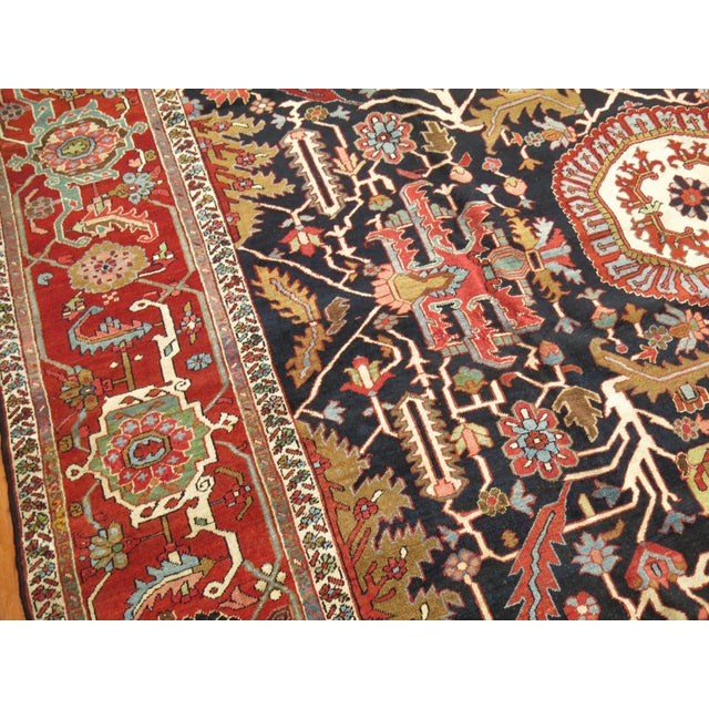 circa 1900 Antique Persian Heriz Serapi Rug. The dark navy/black field and red border stand out on this stellar piece....