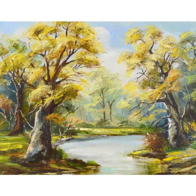 Beautiful autumn landscape of yellow oak trees surrounding a peaceful river in the woods. This vintage 1970's landscape by...