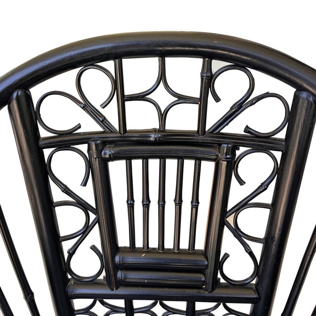 A striking ebonized Brighton Pavilion style corner chair featuring real and faux bamboo construction, intricate fretwork...