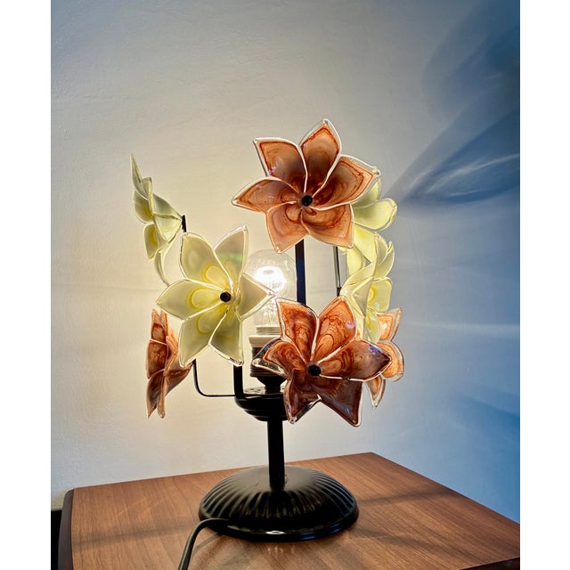 A rare vintage Italian Murano Style table lamp featuring yellow and brown hand-blown glass flowers on a black metal base....
