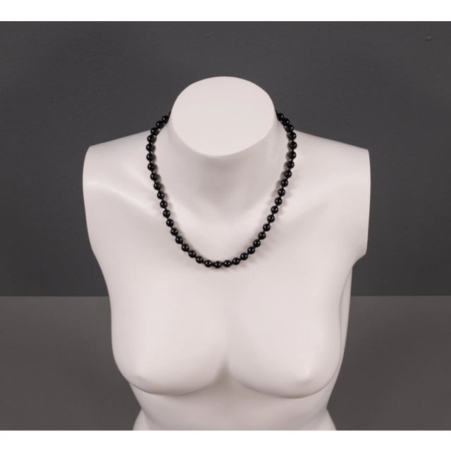 This black agate-colored costume jewelry necklace from the 1950s combines classic charm with a modern touch. The striking...