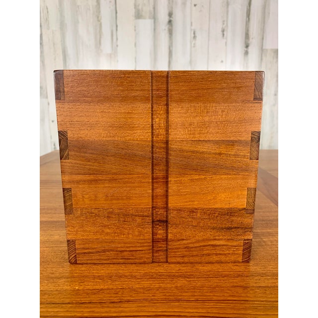 Solid teak ice bucket with box joint corners and plastic insert.