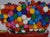 This artwork features a vibrant gumball machine, with its clear globe filled to the brim with colorful gumballs in various...