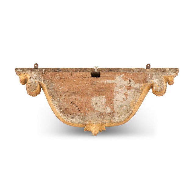 19th century, in the Baroque taste, shelf with a bowed center. On a scroll-carved cartouche backplate, trimmed with carved...