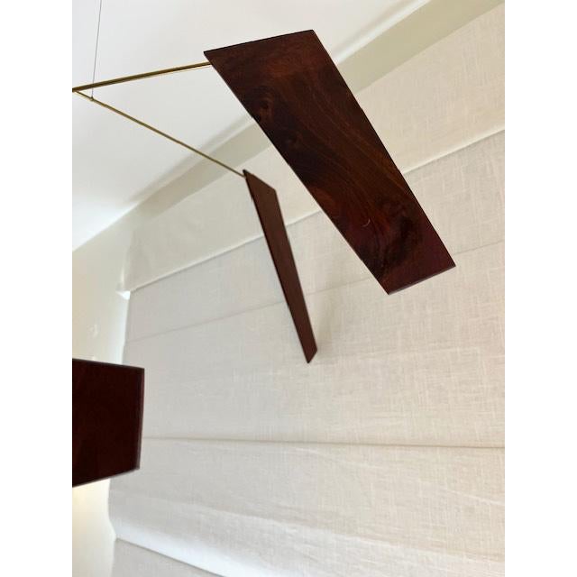 This unique and graceful wood and brass mobile is fabricated with veins of Mara wood from Argentina, with brass armatures....