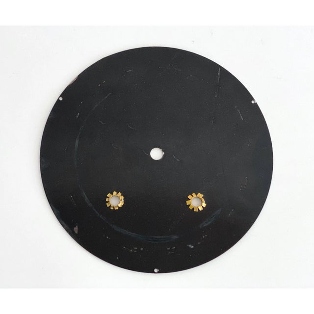 Antique French clock face featuring a bright white enamel surface with contrasting black numbers. Appears to be old new...