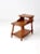 A mid-century wooden end table from around 1950, showcasing a casual ranch-style design. The table features a tiered top...