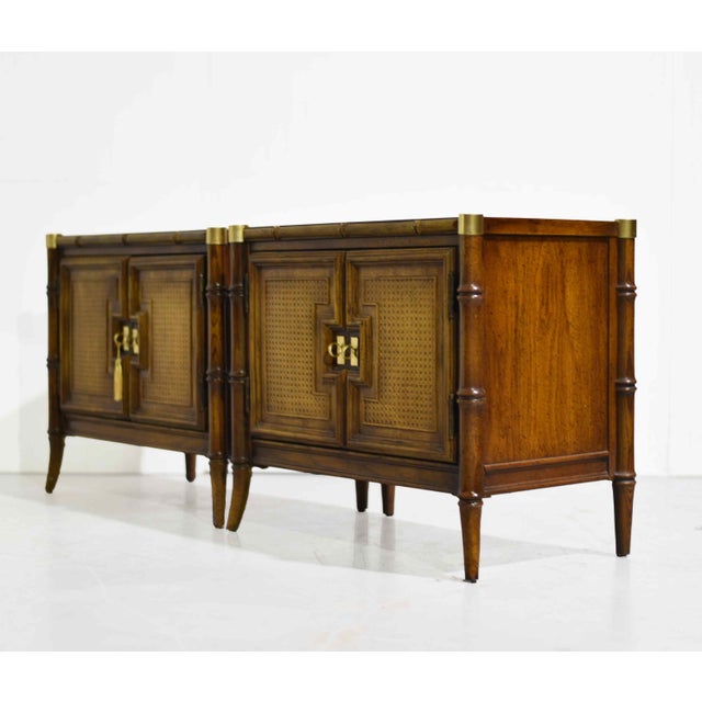 Elevate your space with this stunning pair of mid-century faux bamboo nightstands featuring timeless Hollywood Regency...