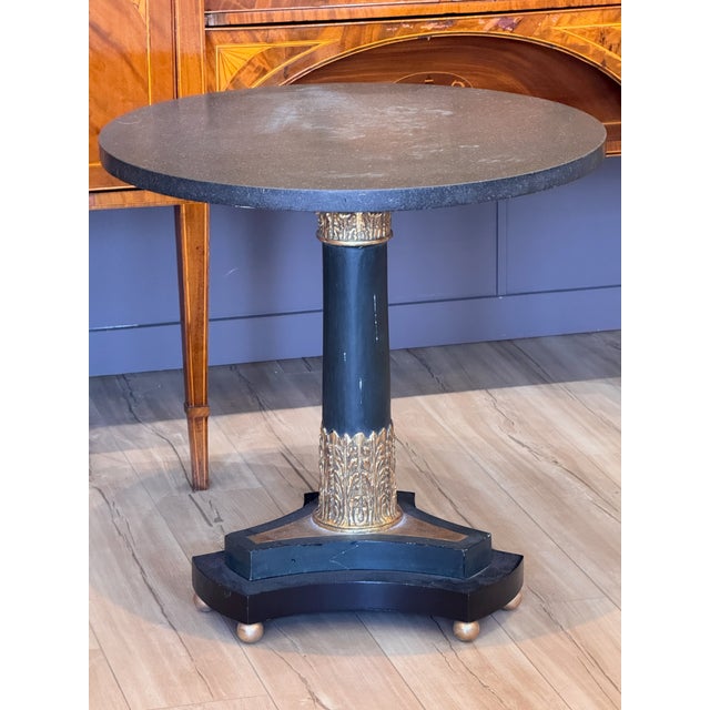 Round marble top above a painted and parcel gilt columnar pedestal with acanthus-carved gilt collar at top and base,...