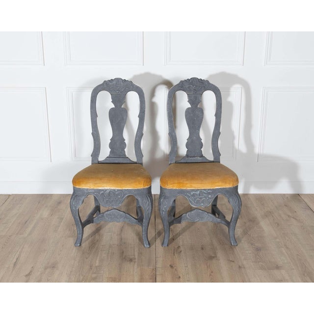 This fine pair of 19th-century Swedish Rococo chairs blends sculptural elegance with a bold, moody palette. Painted in a...