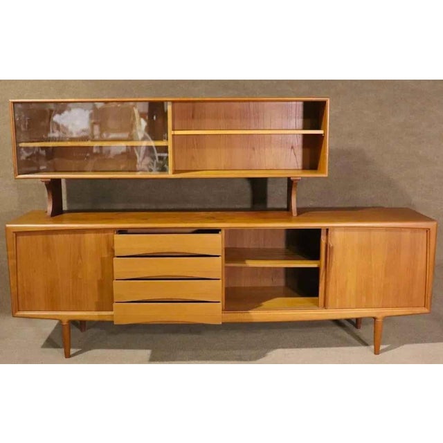 Danish modern design in the style of Arne Vodder, featuring a long teak credenza with cabinet and drawer storage. Topper...