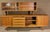 Danish modern design in the style of Arne Vodder, featuring a long teak credenza with cabinet and drawer storage. Topper...