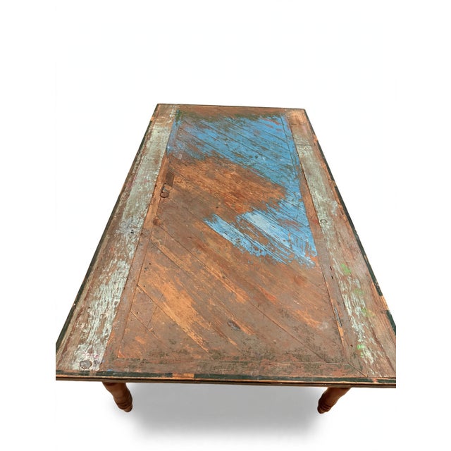 A captivating antique French farmhouse dining table, its generous top crafted from a centuries-old French door — thick...