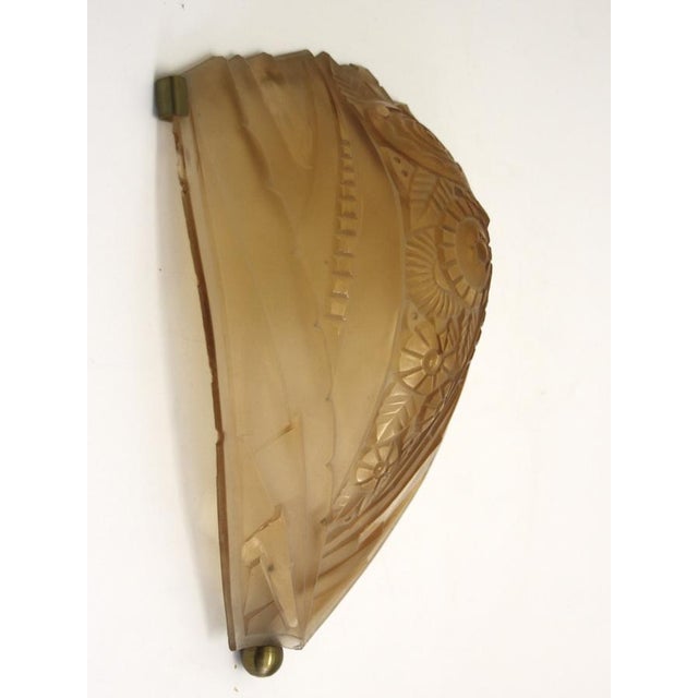 Frameless wall lamp with three brass brackets and an etched glass shade featuring an Art Deco motif. In very good...
