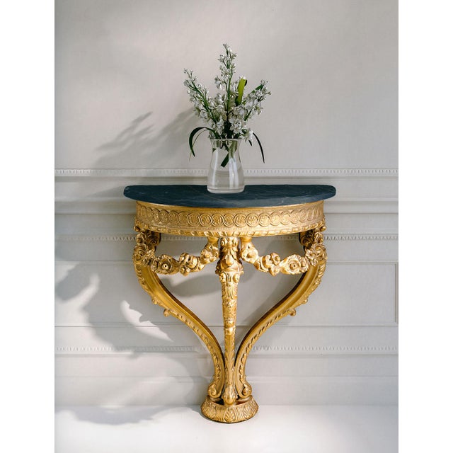Handcrafted in Italy, this wall-mounted console table features an intricately hand-carved frame finished in 24-karat...