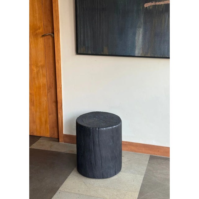 A striking sculptural side table crafted from a substantial piece of solid teak, distinguished by its monolithic...