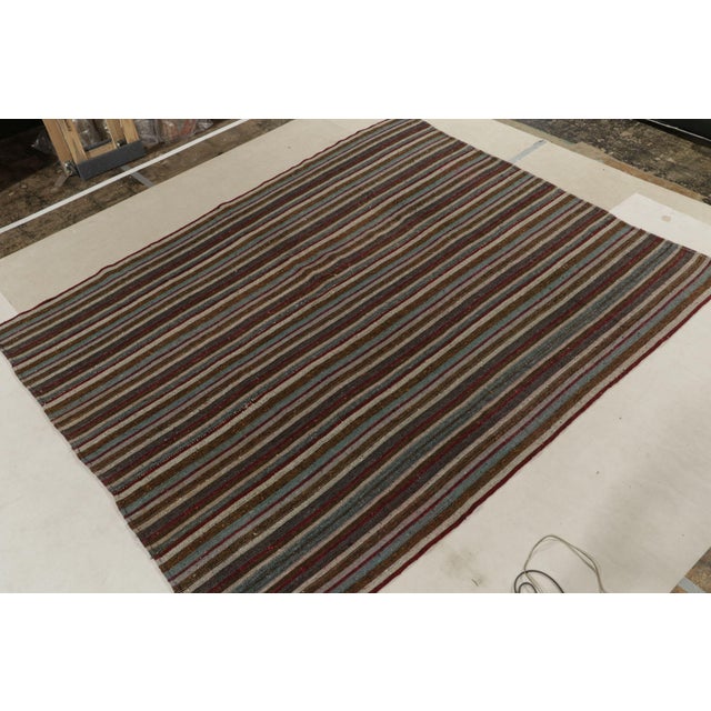 Hand woven in wool originating from Turkey between 1950-1960, this vintage mid-century Kilim enjoys one of the most subtle...