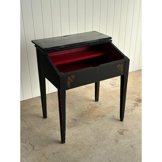 Early American slant front desk in original black paint with hand stenciled vine and grape decoration. Hinged writing...