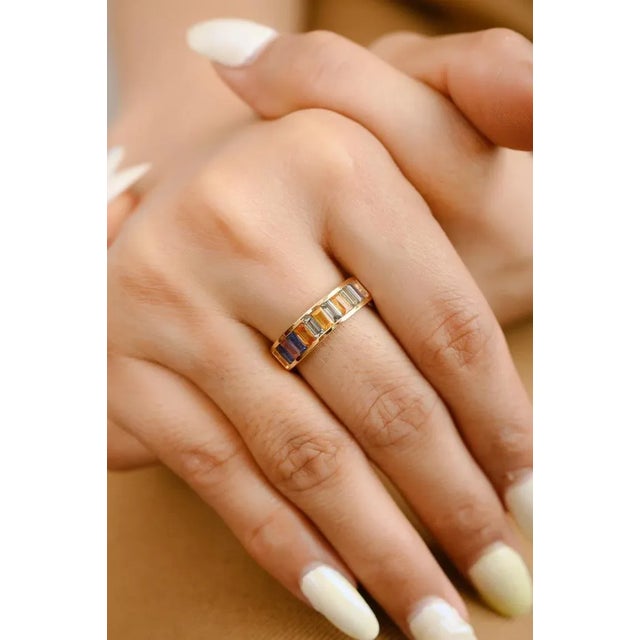 This is part of Chairish’s Fine Jewelry assortment. Channel Set Baguette Multi Sapphire Half Eternity Band in 18K Gold...