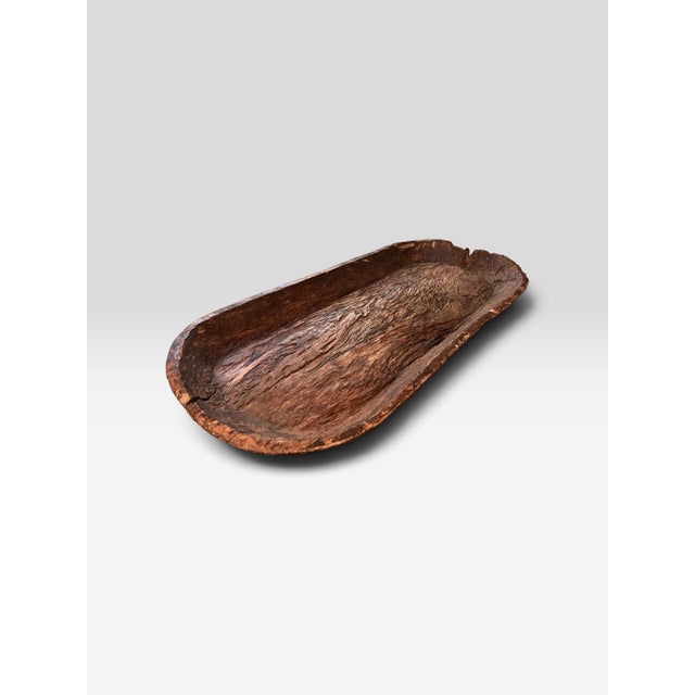 A wonderfully primitive antique wooden dough bowl or trencher, hand-hewn from a single substantial piece of wood and...