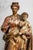 A striking example of 19th-century religious folk art, this substantial hand-carved wooden statue depicts the Mary and...