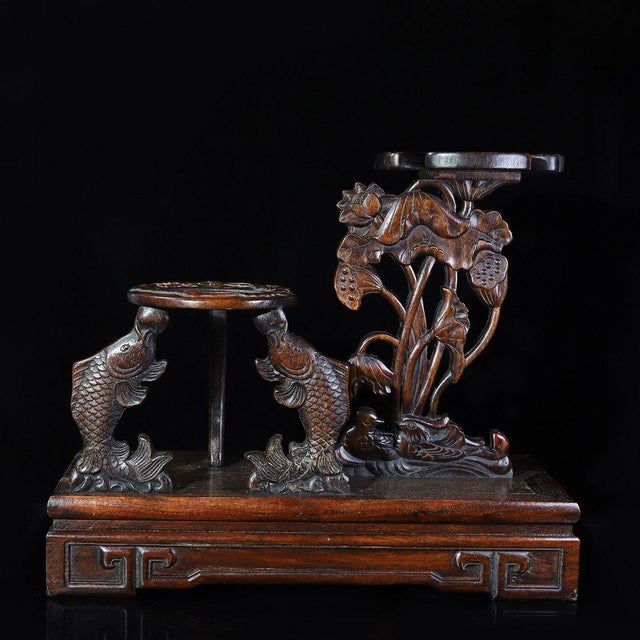 A beautifully crafted Chinese display stand, likely made of Huali (rosewood). The piece features a sturdy rectangular base...