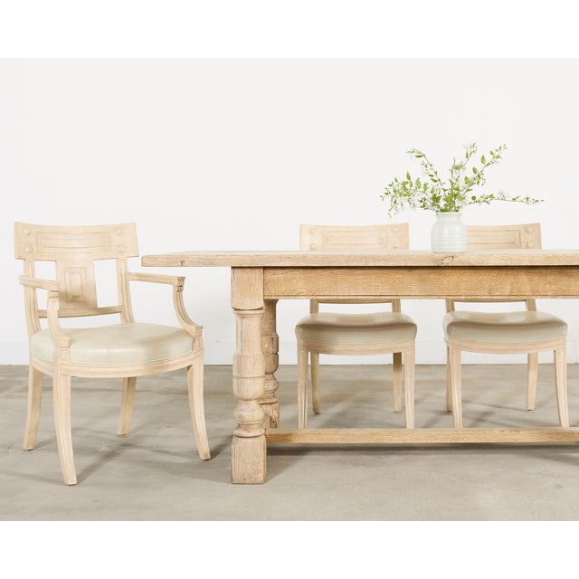 A substantial 20th century French bleached oak farmhouse trestle dining table crafted in the Country Provincial style. The...