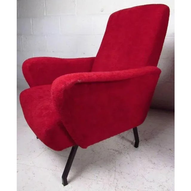 This stylish pair of upholstered lounge chairs with angled metal legs and sculpted arms add to the Italian modern appeal...