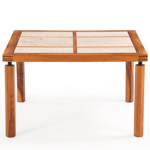 A handsome Italian dining table crafted in richly figured olive wood, featuring a square top inset with six travertine...
