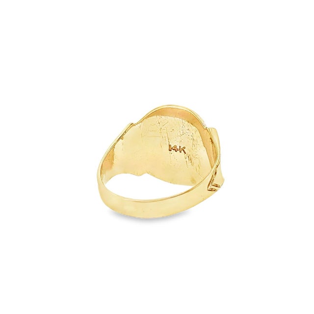 A Vintage 14k yellow gold signet ring featuring a smooth, oval face. The design is simple and bold, with a polished finish...