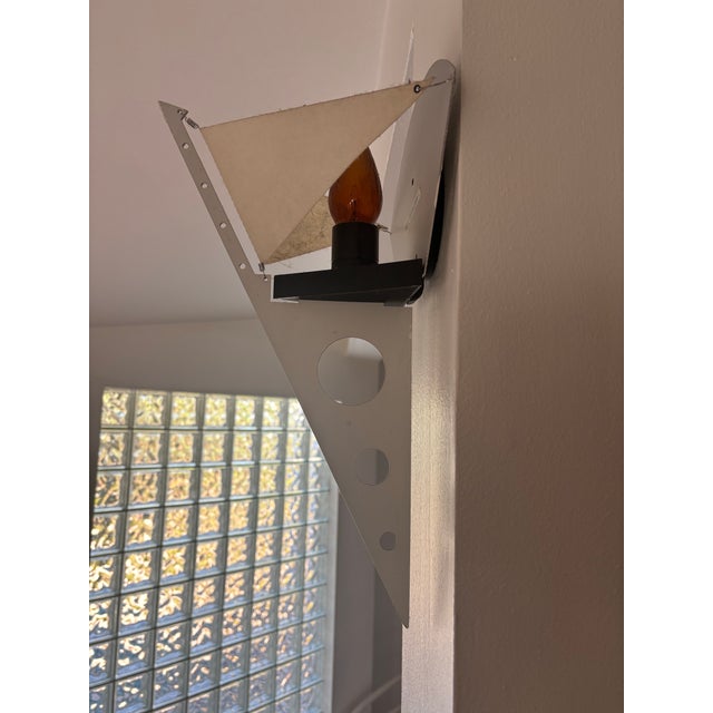 Bold, geometric stainless steel wall sconce with paper shade. Simple yet striking the clean lines will add an impact in...