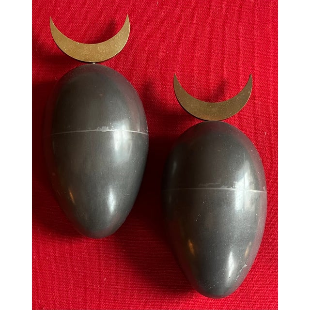 Pair Johan Meijerink (Dutch 1948 - 2011) bronze ovoid egg wall sculptures with crescent finials. The eggs with a gray...