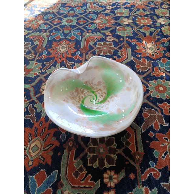 A stunning vintage hand-blown art glass bowl attributed to Murano. The piece features lattimo (milk glass) with vibrant...