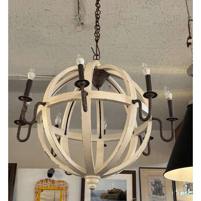 Design Plus Gallery presents a Globe Chandelier from Port & Manor. The fixture has a distressed finish on both the white...